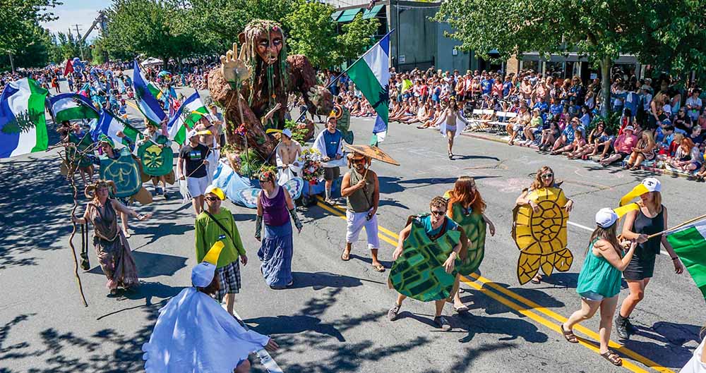 Seattle activities between World Cup matches. Colorful handmade floats and bystanders line the streets of Fremont during the annual Solstice Parade on a sunny June afternoon.